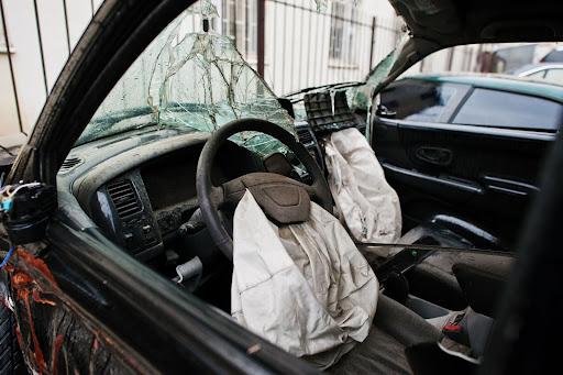 Crash aftermath showing a car cabin with a deflated airbag.