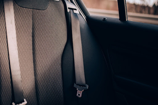 Rear car seats with visible seatbelts, premium upholstery, and safety features.