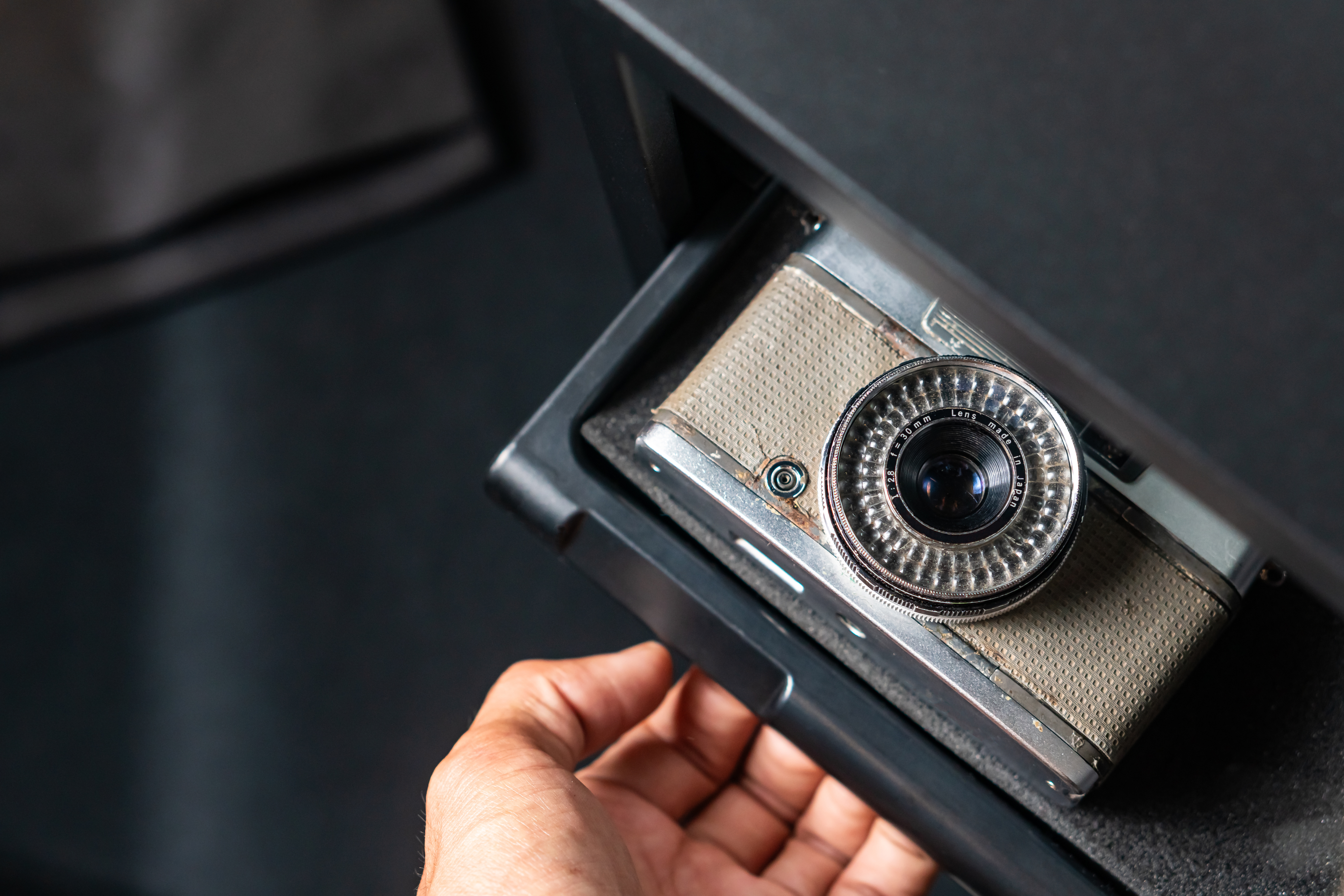 Driver cannot open their car glove box far enough to grab their camera.